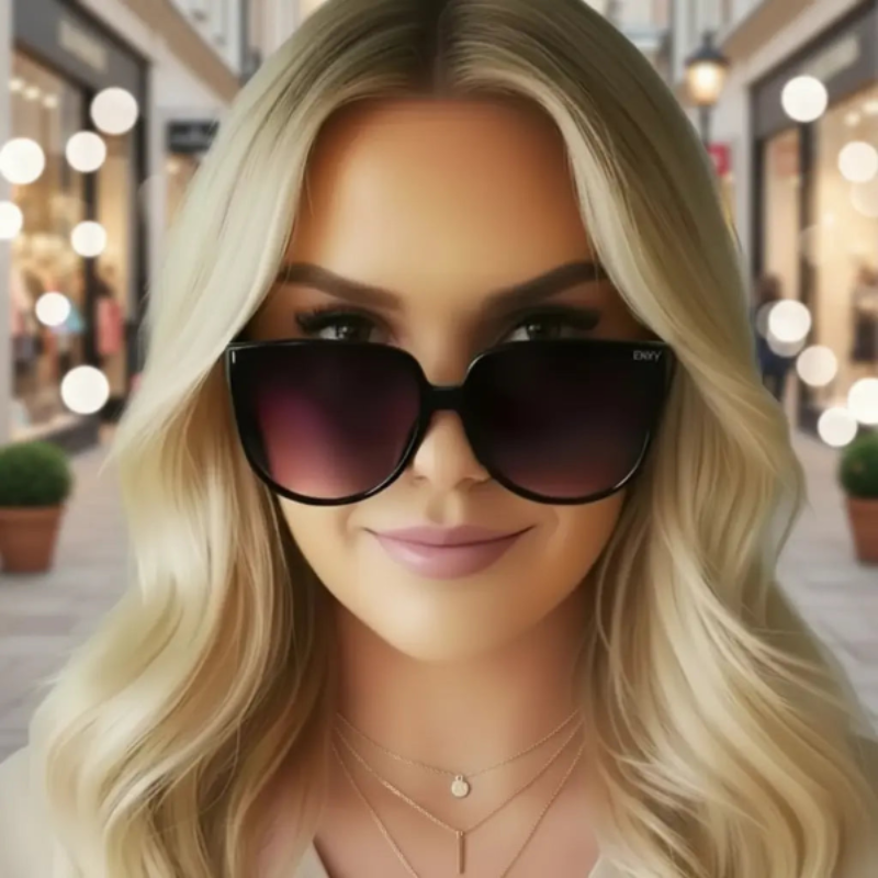 Woman wearing Annabelle oversized envy sunglasses with a blurred background of a street scene