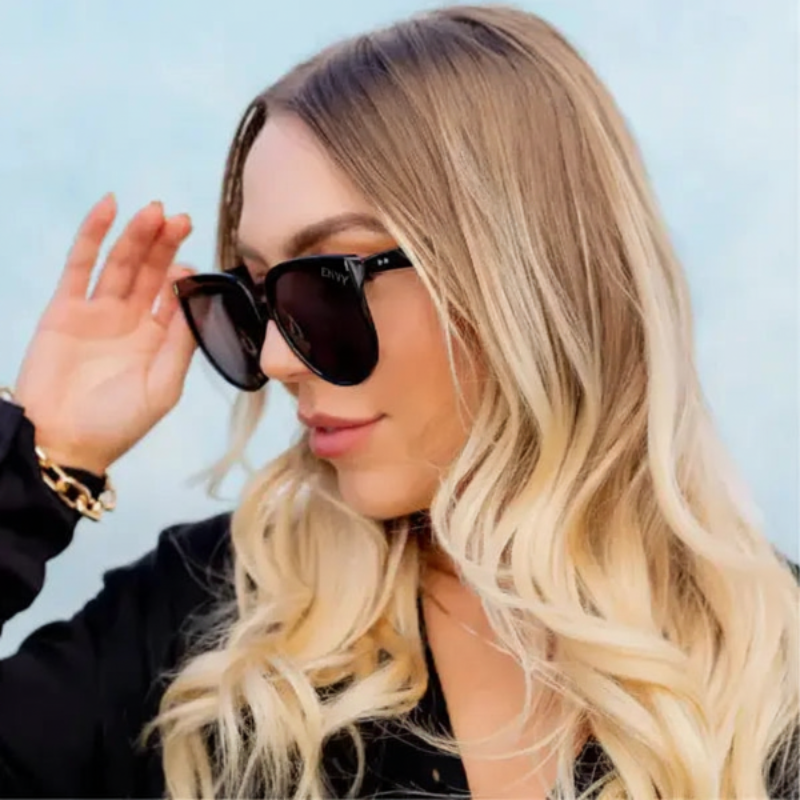 Woman wearing Annabelle oversized Envy Sunglasses with a light blue background