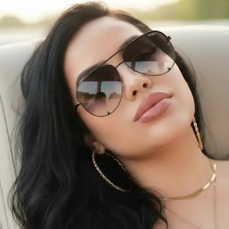 Woman wearing ENVY Black Fade sunglasses with a blurred outdoor background