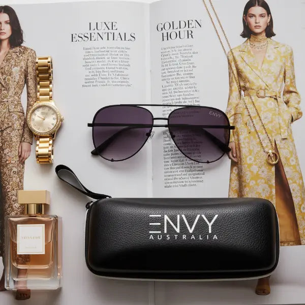 Sunglasses with a case labeled 'ENVY Australia' on an open magazine with fashion images.