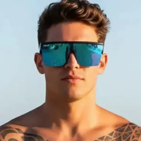 Man wearing blue reflective sunglasses with a clear sky background