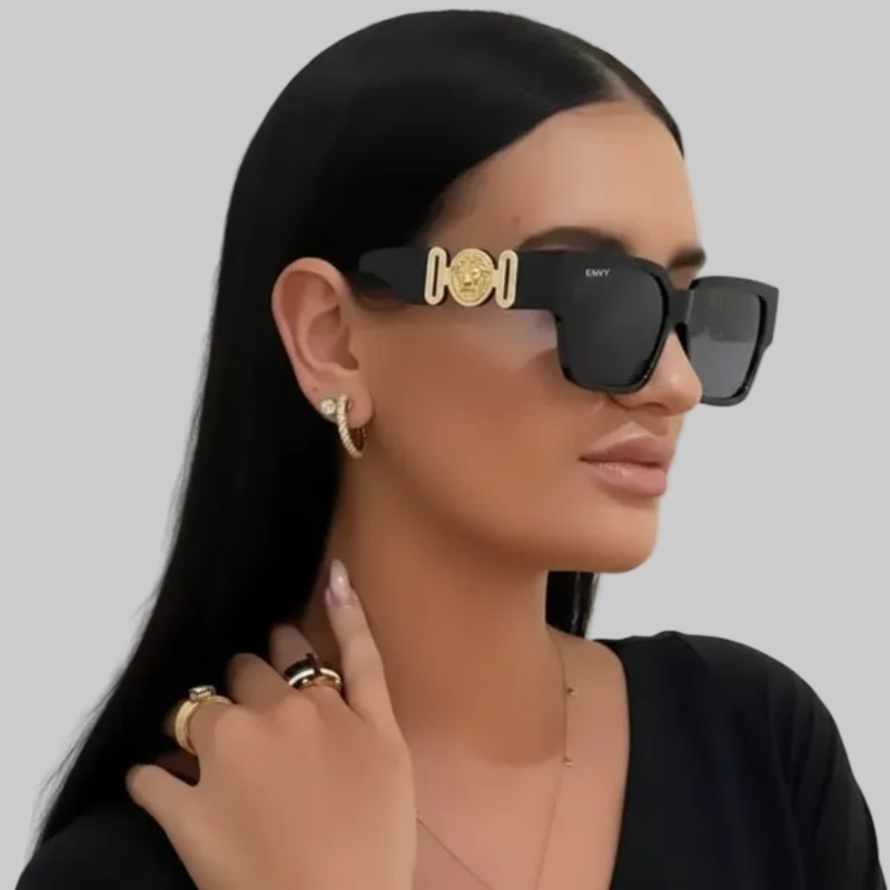 Woman wearing Milan black sunglasses with gold accents against a white background