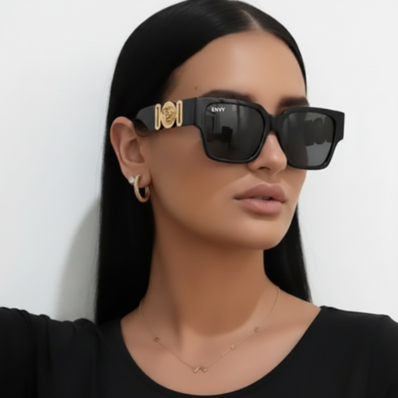 Woman wearing ENVY Milan Deluxe black sunglasses with gold accents on a plain background