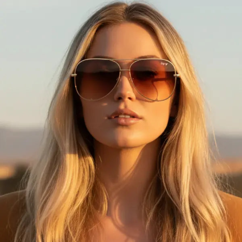 Woman wearing ENVY Ombre Pilot Tansunglasses with a blurred natural background