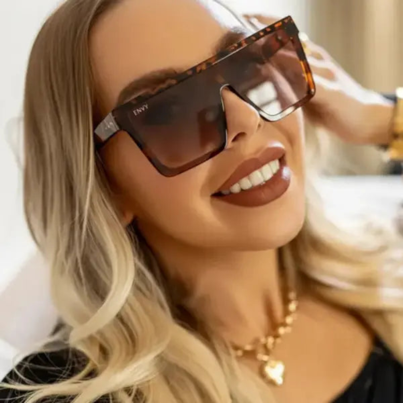 Woman wearing Envy Selena Leopard sunglasses with a blurred background