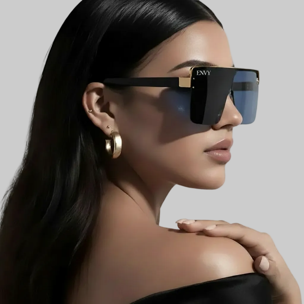 Woman wearing black Envysunglasses with gold accents on a white background