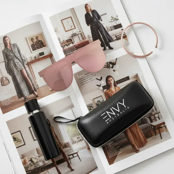 Pink sunglasses and black case on a magazine with 'ENVY Australia' branding.