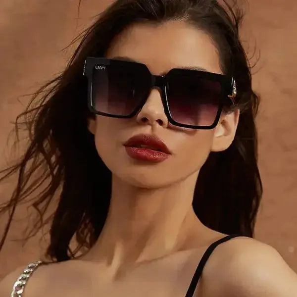 Woman wearing black ENVY sunglasses with a neutral background