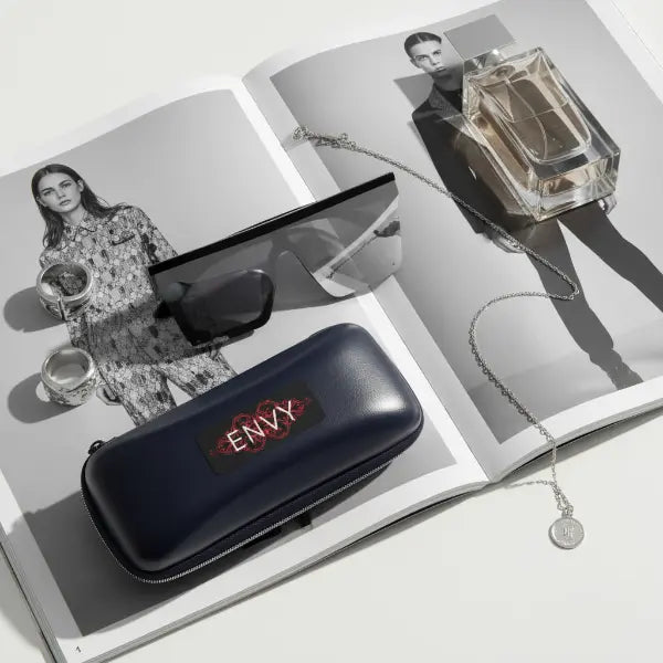 Black 'ENVY' case on an open magazine with fashion and beauty imagery