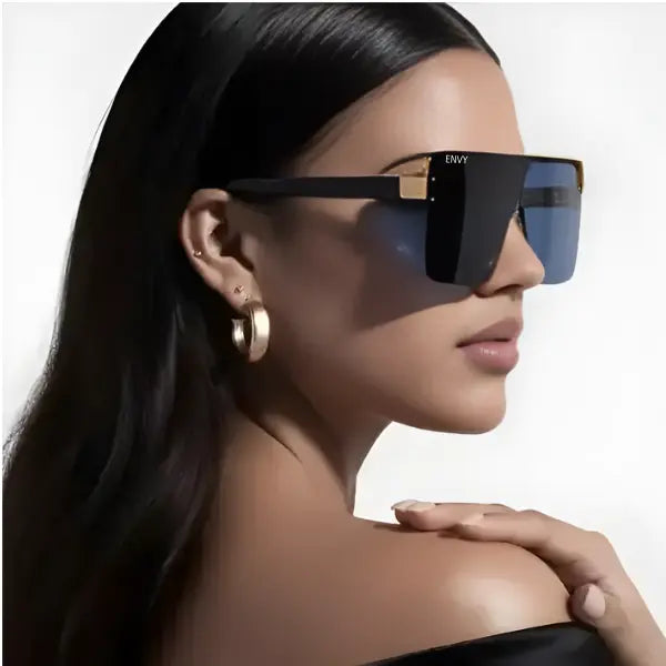 Woman wearing black Envysunglasses with gold accents on a white background